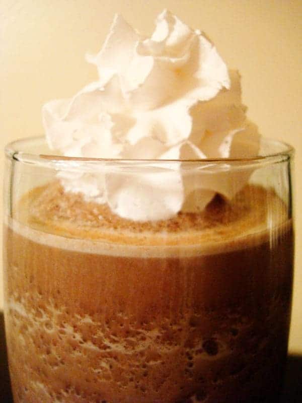 Glass of frozen hot chocolate with whipped cream on top.