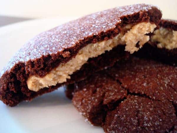 a chocolate cookie split in half with a peanut butter filled middle