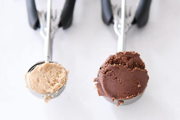 Small cookie scoop with peanut butter filling and bigger cookie scoop with chocolate cookie dough.