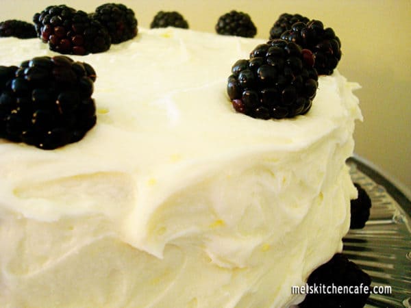 Frosted cake with blackberries on top.