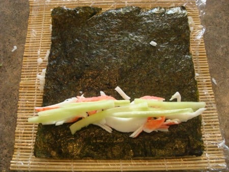 Rice Outside Layer2 crab meat and cucumber sticks on a sheet of nori