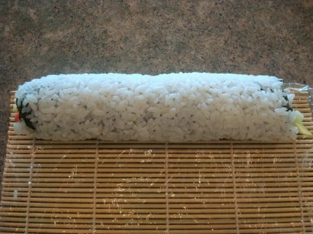 Rice Outside Rolled Roll At End of Mat full sushi roll on a bamboo mat