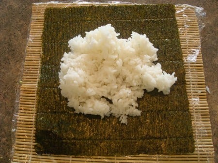 Rice Piled On bamboo mat with sheet of nori and white rice on top