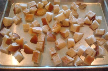 Bread cubes on baking sheet unbaked bread cubes on a cookie sheet