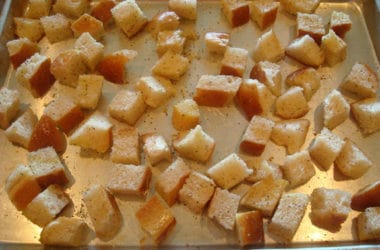 Ready to go in oven unbaked bread cubes on a metal cookie sheet