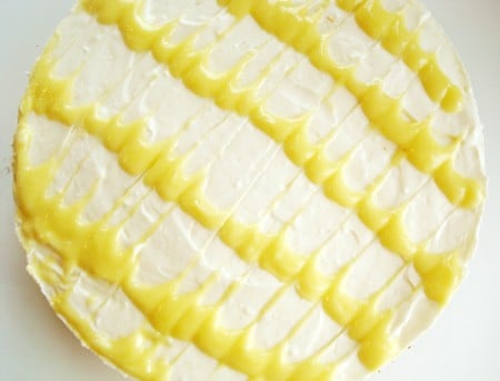 top view of a lemon cheesecake with lemon curd designs on top