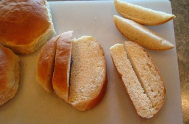 cutting Bread 3 roll cut into 1/2 inch strips on a white cutting board