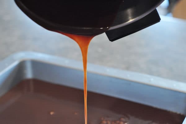 large pot pouring caramel mixture into a pan