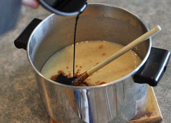 butter mixture in a pot with vanilla extract being poured in