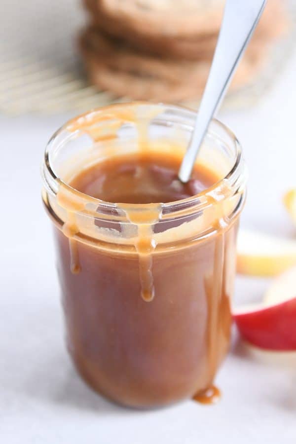 homemade caramel sauce in glass jar with spoon