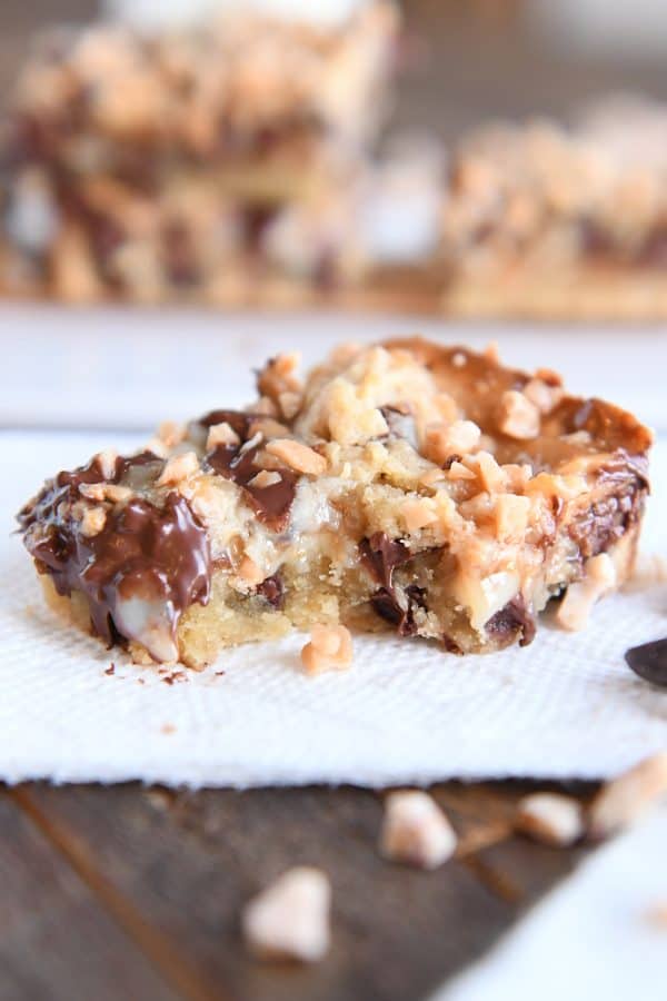 One chocolate chip toffee bar on napkin with bite taken out.