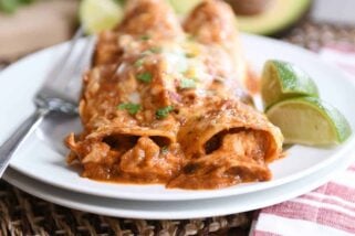 Two of the best red sauce chicken enchiladas on white plate.