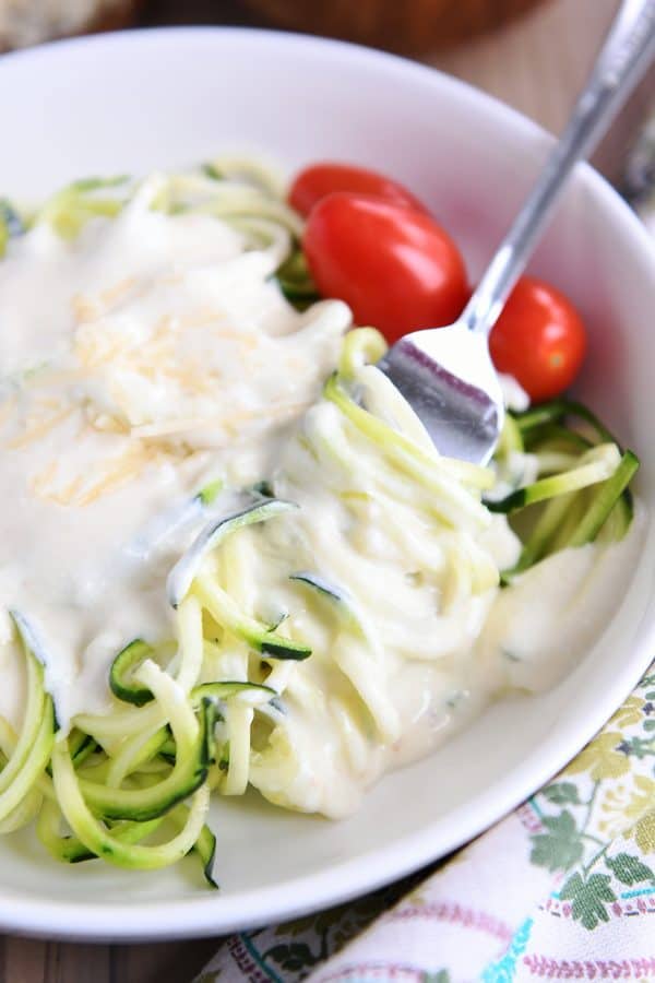 Creamy homemade alfredo sauce recipe over zoodles.