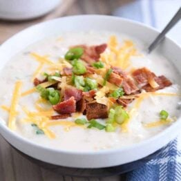 spoon in white bowl with easy loaded baked potato soup