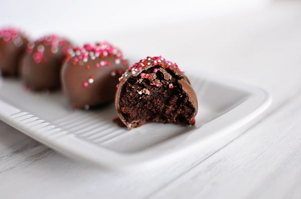 Half eaten brownie truffle lined up next to three other brownie truffles.