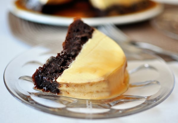 A piece of chocolate flan cake on a glass plate.
