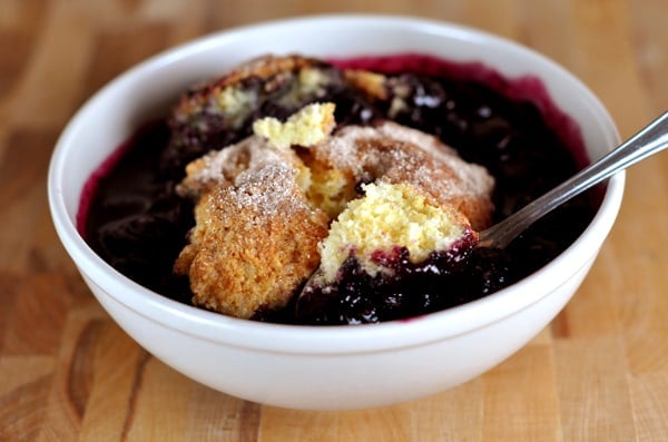 A white bowl full of blueberry cobbler.