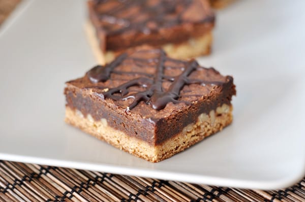A white platter with chocolate congo bars with a chocolate drizzle on top.