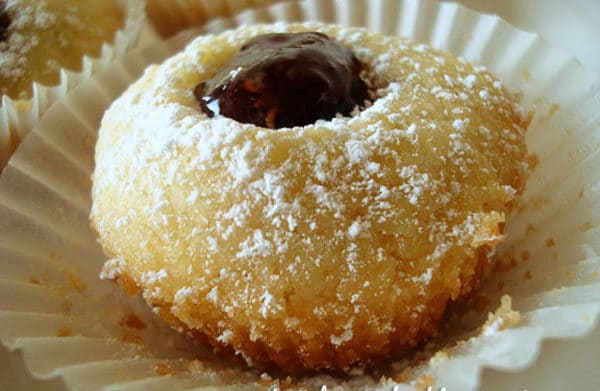 Shortbread cookie with powdered sugar and jam center.