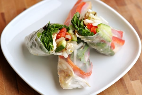 Cut open spring roll on a white plate.