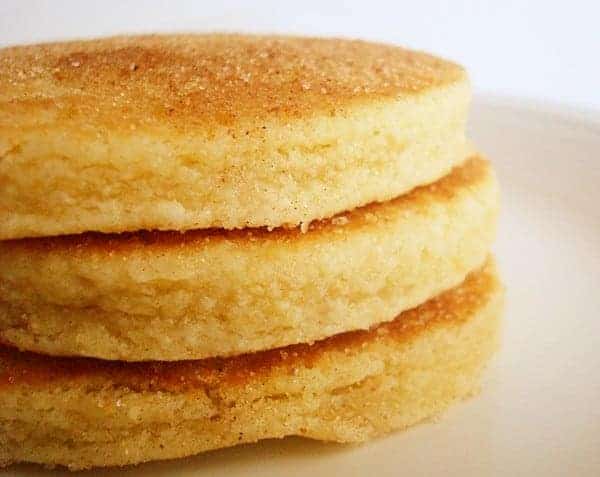 Stack of three thick pancakes on a white plate.