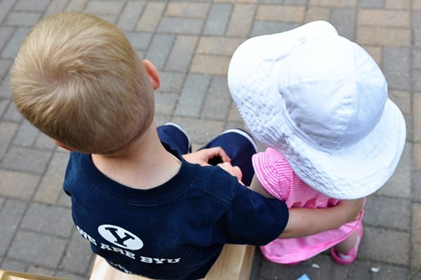 a little boy and little girl sitting by each other