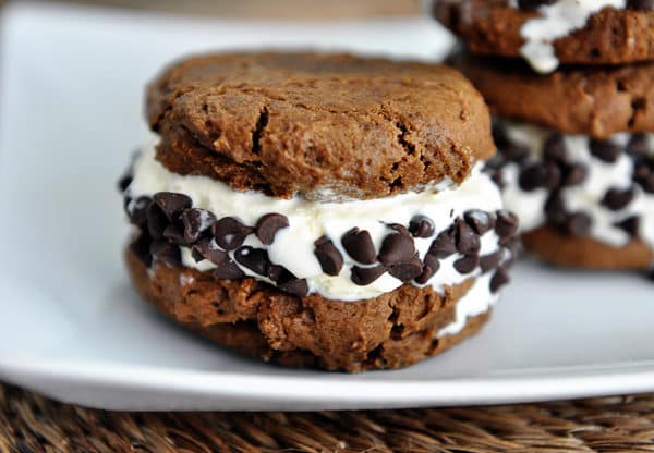 A chocolate pumpkin chocolate chip ice cream sandwich on a white plate.