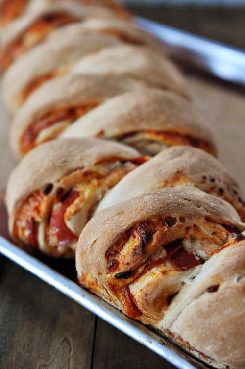 A cookie sheet full of whole wheat pepperoni pull-apart rolls.
