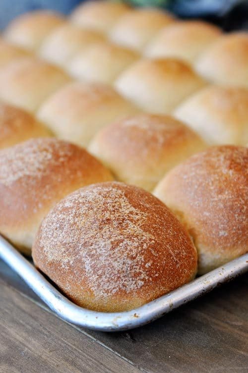 a cookie sheet full of golden brown cooked rolls