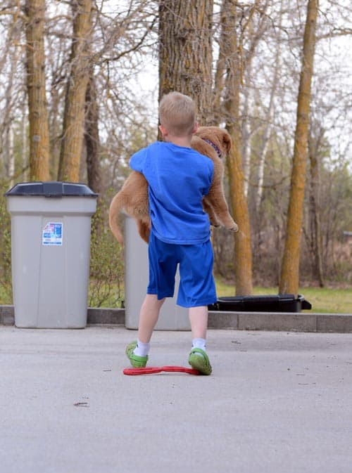 A little boy holding a puppy.