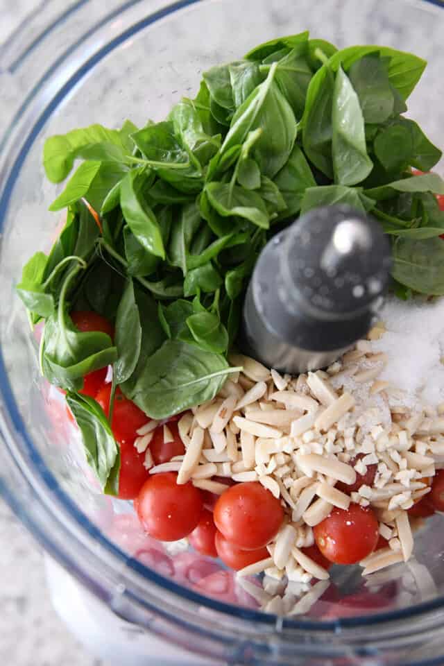 Basil, cherry tomatoes, almonds and salt in food processor.