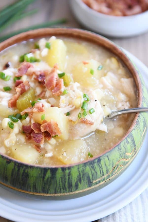 Green bowl filled with pressure cooker chicken corn chowder with bacon on top and spoon in the side.