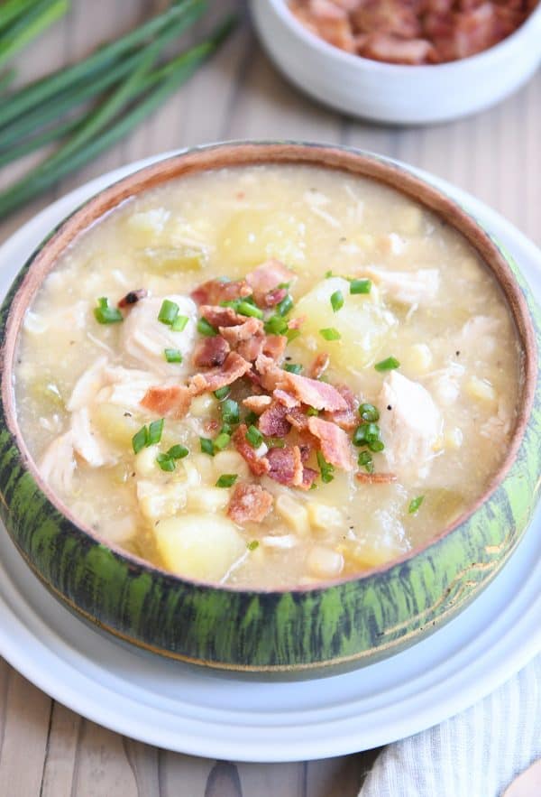 Green bowl filled with pressure cooker chicken corn chowder with bacon on top.