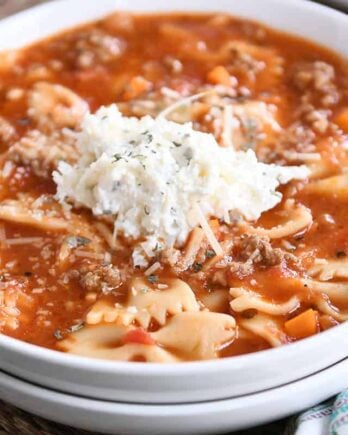 White bowl filled with pressure cooker lasagna soup and dollop of cheesy ricotta mixture.