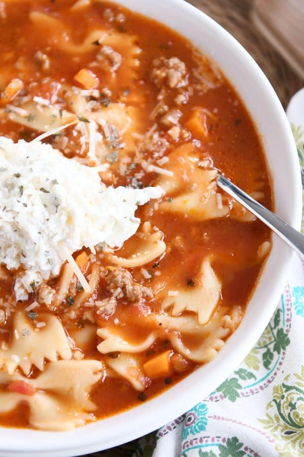 Top down view of White bowl filled with pressure cooker lasagna soup and dollop of cheesy ricotta mixture.