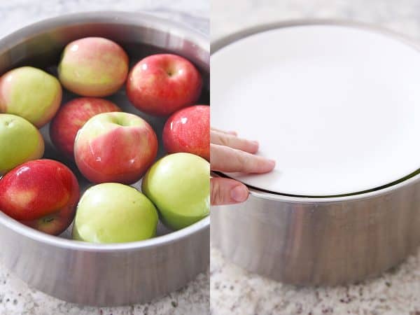 Soaking washed apples in hot water in stainless pot.
