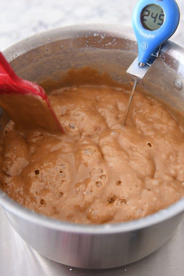 Cooking homemade caramels to 245 degrees.