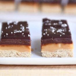 Two homemade grown up Twix bars on white tray.
