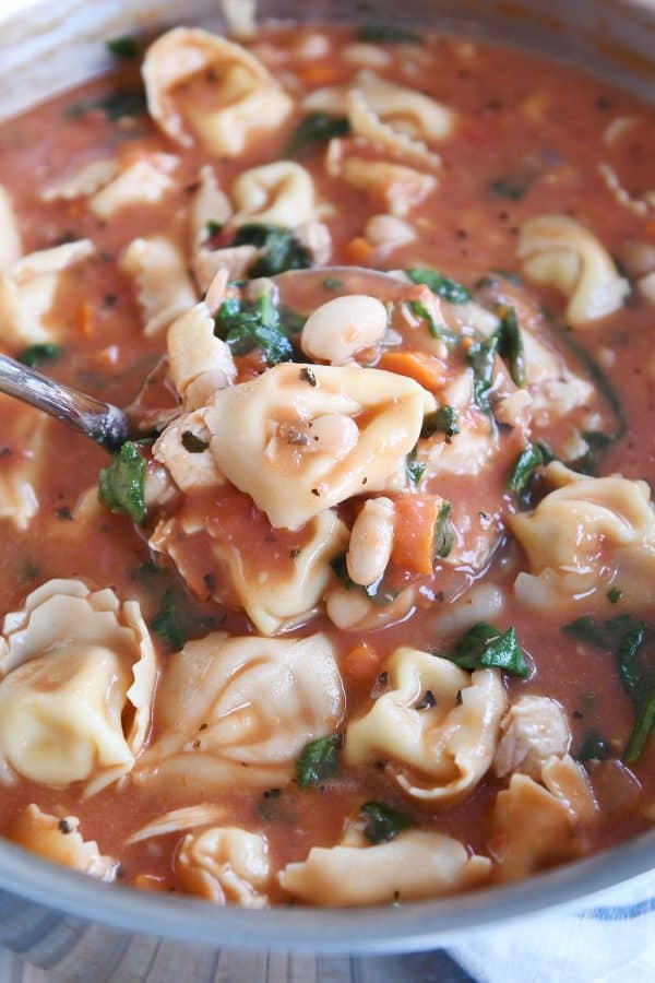 Ladle of quick and easy creamy tuscan tortellini soup.