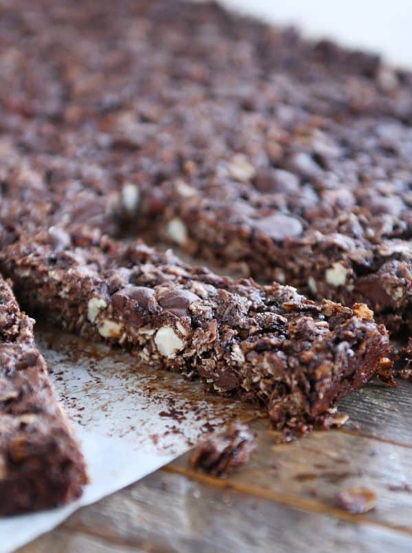 Cutting apart dark chocolate brownie granola bars into thin rectangles.