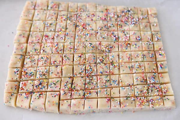 Cutting funfetti shortbread bites into tiny squares.