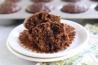 double chocolate zucchini muffin in half on muffin liner