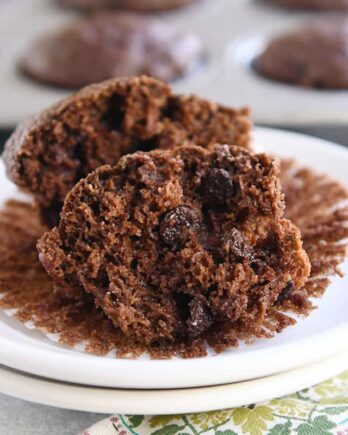 double chocolate zucchini muffin in half on muffin liner