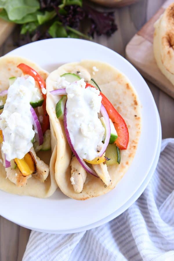 Top down view of chicken tzatziki wrap on white plate.