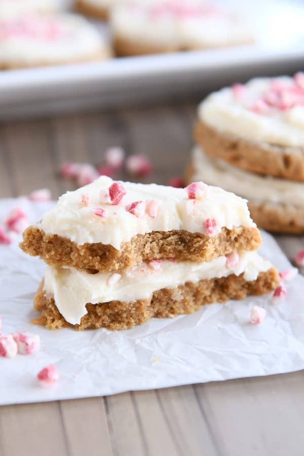 Soft gingerbread sugar cookie broken in half and stacked on white parchment paper.