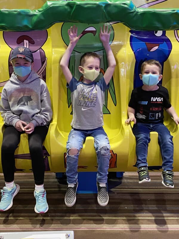 three children riding amusement park ride