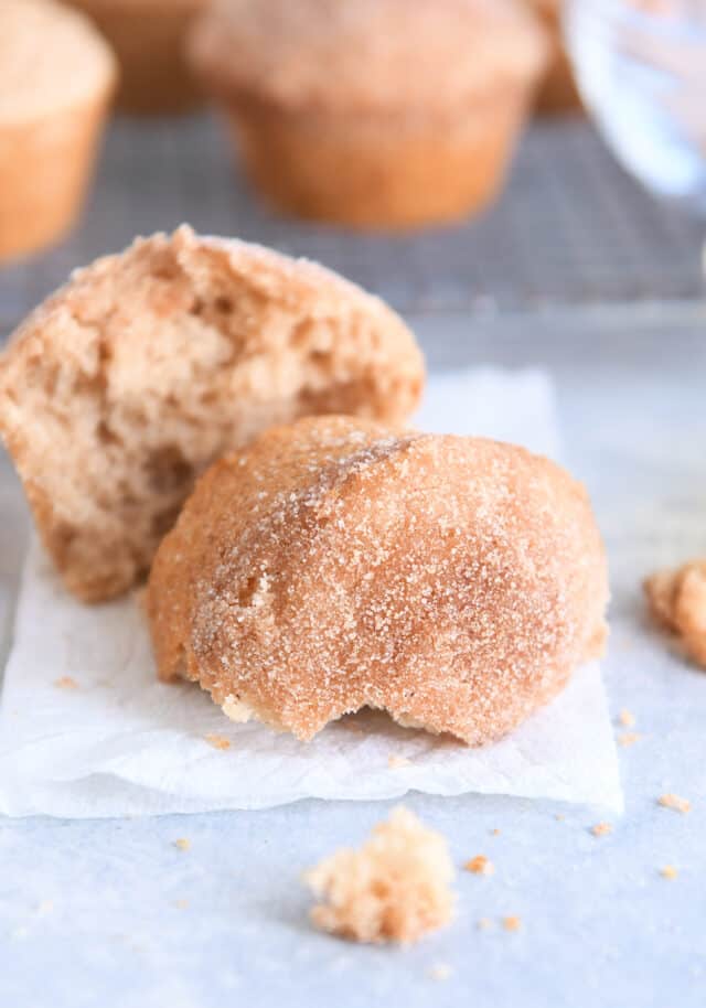 Half of doughnut muffin on white napkin.