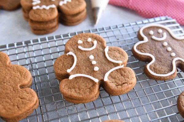 several decorated gingerbread people cookies on wire rack
