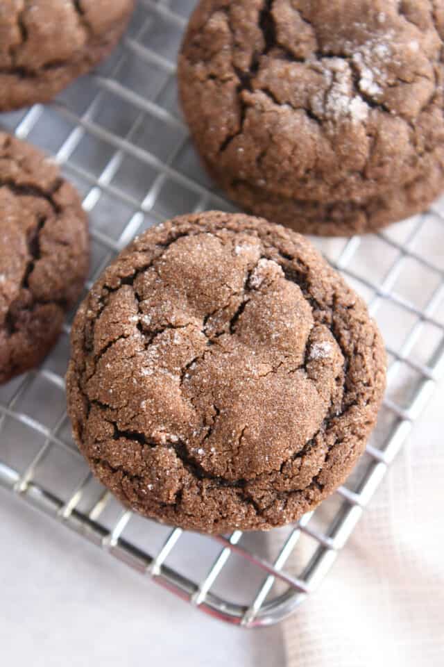 Chewy chocolate ginger molasses cookie on wire cooling rack.