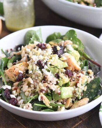 serving of kale and wild rice salad in white bowl with fork